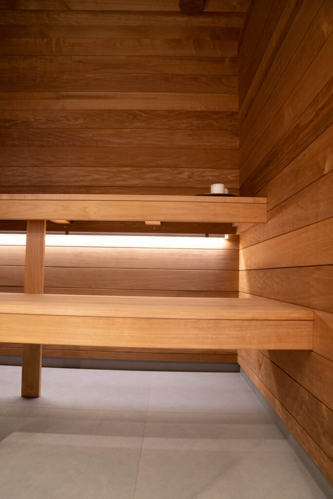 Träbastu med olika nivåer av sittplatser och inbyggd belysning
